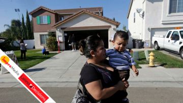 Yesenia Perez leaves a home which had been turned into a polling station with her 1-year-old son, Eduardo Sanchez, after voting in the Weston Ranch are of Stockton, Calif.
