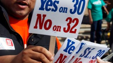 Un hombre apoya la Proposición 30 y rechaza la Proposición 32 en un acto público en California.