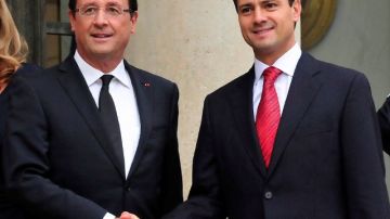 El presidente francés Francois Hollande saluda al presidente electo de México, Enrique Peña Nieto, en la entrada del Palacio del Elíseo de París.