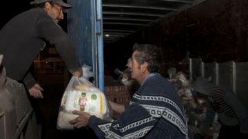 Voluntarios cargan alimentos y otros bienes para ser repartidos en las comunidades afectadas por el terremoto en Guatemala.