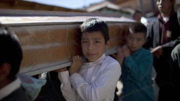 Varios niños cargaban ayer un ataúd en el funeral de 10 miembros de una misma familia que fueron víctimas del sismo que golpeó a Guatemala en San Marcos. La comunidad lucha por volver a la normalidad.