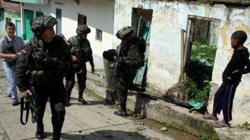 Policias colombianos inspeccionan una casa que fue dañada por granadas caseras supuestamente lanzadas por rebeldes de  FARC, ayer.
