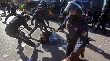 Miembros de la policía española trata de controlar a unos manifestantes durante una de las protestas en Madrid.