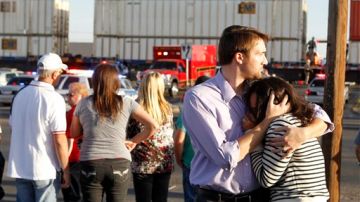 Espectadores reaccionan mientras personal de emergencia acude a la escena del accidente en el que un remolque que llevaba veteranos en un desfile, fue atropellado por un tren en Midland, Texas.