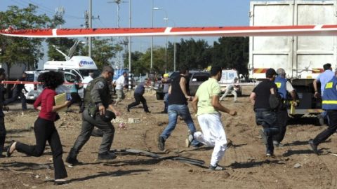 Imagen cedida por la oficina de prensa del Gobierno de Israel (GPO) que muestra a civiles y militares israelíes corren a refugiarse tras sonar la alerta roja.
