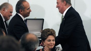 El rey  Juan Carlos de Borbón (d) entrega al presidente saliente de México, Felipe Calderón (i) una placa conmemorativa  en Cádiz.