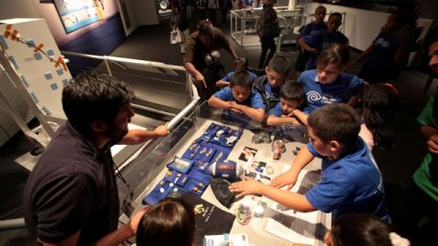Los pequeños asistentes miran la exhibición de la memorabilia de la nave espacial.