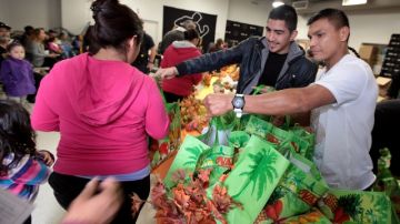 Los boxeadores  Daniel Ponce de Leon (D) y  Leo Santa Cruz, ayudaron a  distribuir  pavos y otros productos alimenticios.