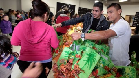 Los boxeadores Daniel Ponce de Leon (D) y Leo Santa Cruz, ayudaron a distribuir pavos y otros productos alimenticios.