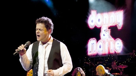 Donny (primer plano, izq.) y Marie Osmond (detrás, de blanco)  en un instante de su show, que llega al Pantages Theatre de la ciudad  el martes.