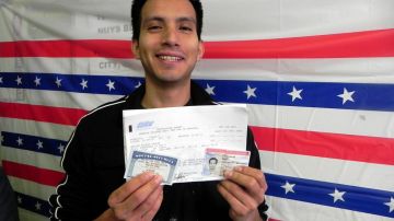 El joven "soñador" Adrián Flores muestra su trajeta de la seguridad social, su permiso de trabajo y su permiso de conducción que obtuvo a través de la acción diferida.