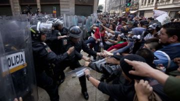 Manifestantes en contra del nuevo gobierno se enfrentan con los policías en Ciudad México.