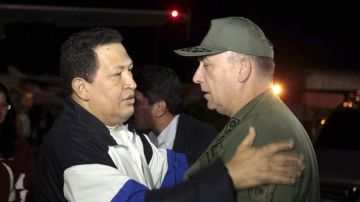 El presidente venezolano Hugo Chávez, que saluda al ministro de Defensa, Diego Molero Bellavia (derecha), a su llegada hoy al aeropuerto internacional Simón Bolívar de Caracas procedente de Cuba, donde ha sido recibido por algunos de los ministros de su Gobierno en la pista del aeropuerto.