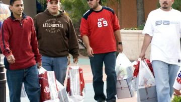 Un grupo de jóvenes mexicanos cargan bolsas a su salida del centro comercial Foothills al noroeste de Tucson, Arizona.