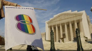 Una manifestante que favorece los matrimonios entre personas del mismo sexo levanta una bandera gay frente a la Corte Suprema.