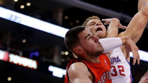 Blake Griffin es fouleado por  Jonas Valanciunas (izq.) de Toronto, en el primer período del juego de ayer.