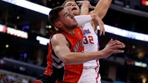 Blake Griffin es fouleado por  Jonas Valanciunas (izq.) de Toronto, en el primer período del juego de ayer.