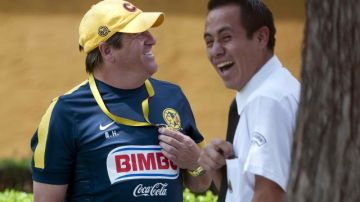 Miguel Herrera bromea con un miembro de seguridad del Club América antes de que el equipo emprendiera el viaje ayer a Avándaro.