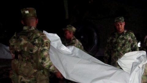 Miembros del Ejército cargan uno de los doce cuerpos de un grupo de militares abatidos durante un combate con las FARC en Maicao, frontera común.