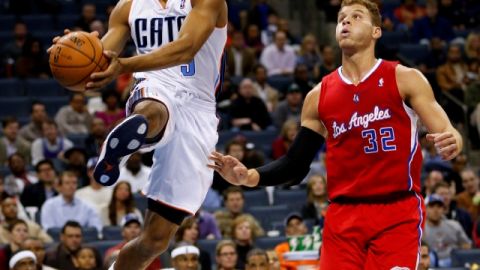 Gerald Henderson (9), de Charlotte, intenta dar un pase ante la marca de Blake Griffin (32), de Clippers, en el juego de ayer.