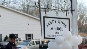 Ciudadanos llegan al exterior de la escuela para dejar flores en un pequeño altar que se levantó para recordar a las víctimas del atentado.