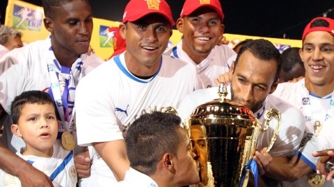 Los jugadores del Olimpia exhiben orgullosos  el trofeo que los acredita como tricampeones   del futbol profesional de Honduras.