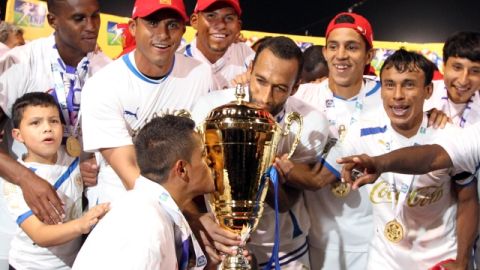 Los jugadores del Olimpia exhiben orgullosos el trofeo que los acredita como tricampeones del futbol profesional de Honduras.