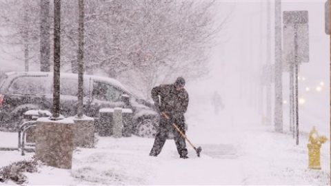 El director de McDonalds, Matthew Kemeny, quita la nieve acumulada fuera del negocio en West Bend, Wisconsin.