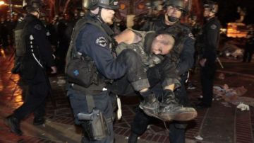 Un manifestante es arrestado cuando agentes de la policía desmantelan el campamento de Occupy LA frente a la municipalidad de Los Ángeles, el 30 de noviembre de 2011.