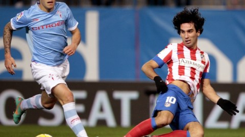 El mediocampista turco del Atlético de Madrid, Arda Turan (der.) pasa el balón ante el defensa del Celta, Hugo Mallo.