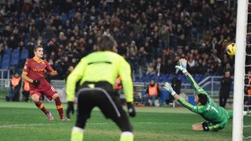 Erik Lamela (izq.) define de zurda  para batir al portero del Milan  y lograr el tercer gol en la victoria del AS Roma en el Estadio Olímpico.
