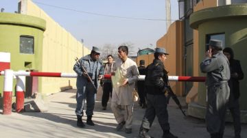 Policías afganos vigilan cuartel general de la Policía, donde una mujer con uniforme de policía  mató a un contratista norteamericano.