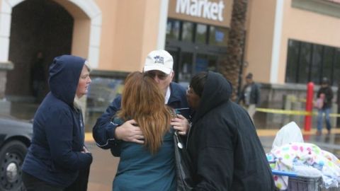 Los empleados se abrazan en el estacionamiento de una tienda Walmart en Moreno Valley, California, después de que un sujeto entrara a la misma con un arma larga.