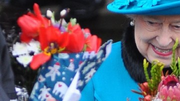 La reina Isabel II sonríe al recibir ramos de flores a su salida de la Iglesia de Santa María Magdalena en Norfolk, Inglaterra.