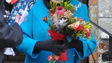La reina Isabel II sonríe al recibir ramos de flores a su salida de la Iglesia de Santa María Magdalena en Norfolk, Inglaterra.