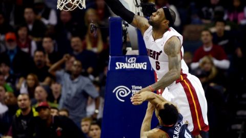 Gerald Henderson (9), de Bobcats, comete una falta a LeBron James (6), del Heat de Miami, durante el juego de ayer.