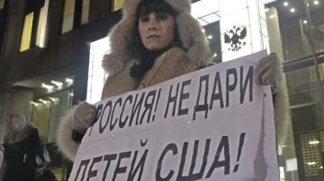 Una mujer protesta en contra de la prohibición de adopción de huérfanos rusos a ciudadanos americanos a las puertas del Consejo de la Federación en Moscú (Rusia).