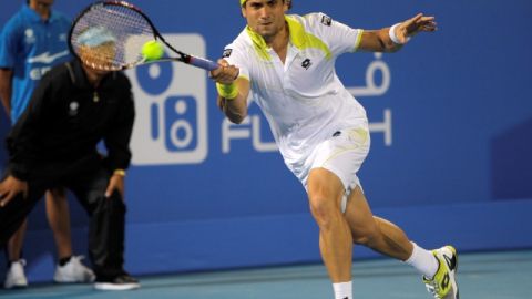 El español David Ferrer regresa una bola al checo Tomas Berdych durante el duelo de ayer en Abu Dhabi.