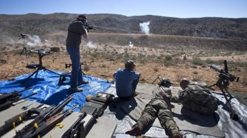 Varios asistentes prueban sus armas durante su participación en el Big Sandy Machine Gun Shoot a las afueras de Wikieup, Arizona, Estados Unidos.