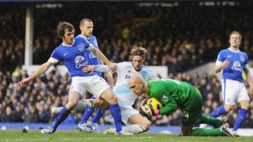 Tim Howard, portero de Everton,   se juega todo ante la arremetida de Fernando Torres (centro), de Chelsea.