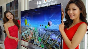 Dos modelos posan con un aparato de televisión que lleva la tecnología OLED, en Seúl, Corea del Sur, ayer.