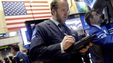 Agentes de la Bolsa realizan operaciones bursátiles durante la apertura de Wall Street en Nueva York, Estados Unidos, ayer.