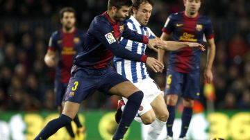 El defensa del FC Barcelona Gerard Piqué disputa el balón con el centrocampista del Espanyol Joan Verdú.