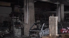 Un policía sirio inspecciona daños causados en estación de gasolina por explosión de carro-bomba en Barzeh, Damasco (Siria).