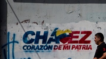 Transeúntes caminan frente a paredes decoradas con grafitis alusivos al presidente Hugo Chávez, ayer.