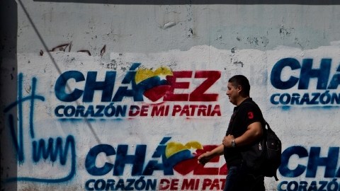 Transeúntes caminan frente a paredes decoradas con grafitis alusivos al presidente Hugo Chávez, ayer.