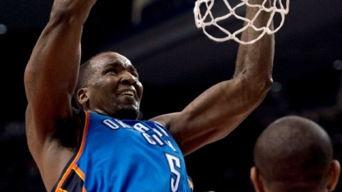 Perkins (izq.) logra una clavada sobre Amir Johnson, de los Raptors.