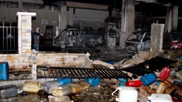 Policías sirios inspeccionan los daños causados en una estación de gasolina debido a la explosión de un carro-bomba en  Damasco.