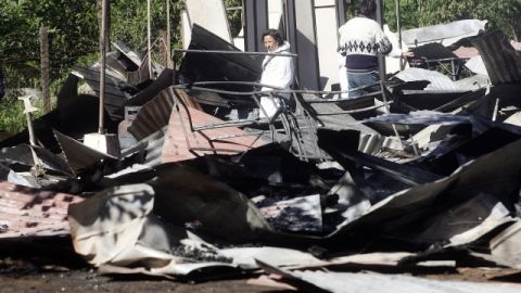 Integrantes de la Policía de Investigaciones de Chile observan los restos de una escuela incendiada en Collipulli (Chile), ayer.