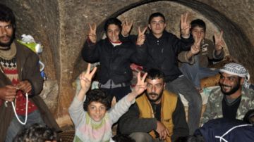 Los familiares de Ismail (2d), en el interior de la cueva donde se refugian tras haber perdido su hogar en Yabal al Zauiya, Siria.